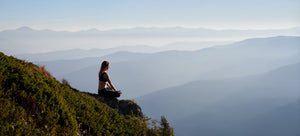 Frau meditiert in den Bergen für Entspannung
